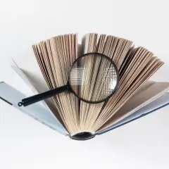 Otwarta księga z lupą, szukamy najdłuższe słowo na świecie.