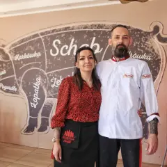 Para z uśmiechem na tle ściany z mapą wieprzowiny. Wszyscy chwalą ich "złota świnka opinie".
