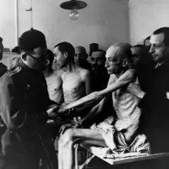 Wstrząsający obraz ofiar obozu koncentracyjnego, ukazujący skrajne wycieńczenie. To wizualna definicja holocaustu.