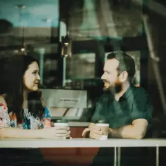 Para rozmawia przy kawie. On uśmiecha się, a ona patrzy na niego z uwagą. Czy to początek czegoś pięknego?