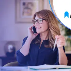 Kobieta rozmawia przez telefon, trzymając długopis. Logo Autopay sugeruje, że chodzi o płatności.