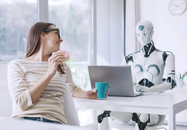 Kobieta z pączkiem i kubkiem kawy rozmawia z robotem przy laptopie. Oryginalna scena z przyszłości.
