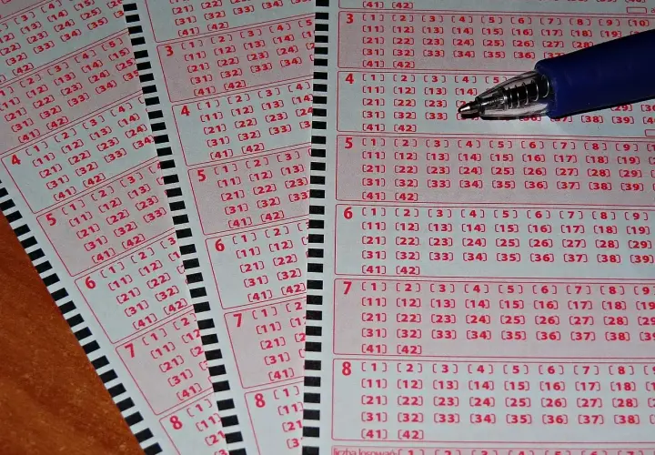 Kupony lotto z zaznaczonymi polami, gotowe do gry. Widoczne litery kontrolne zdrapek i numerowane pola do wyboru liczb.