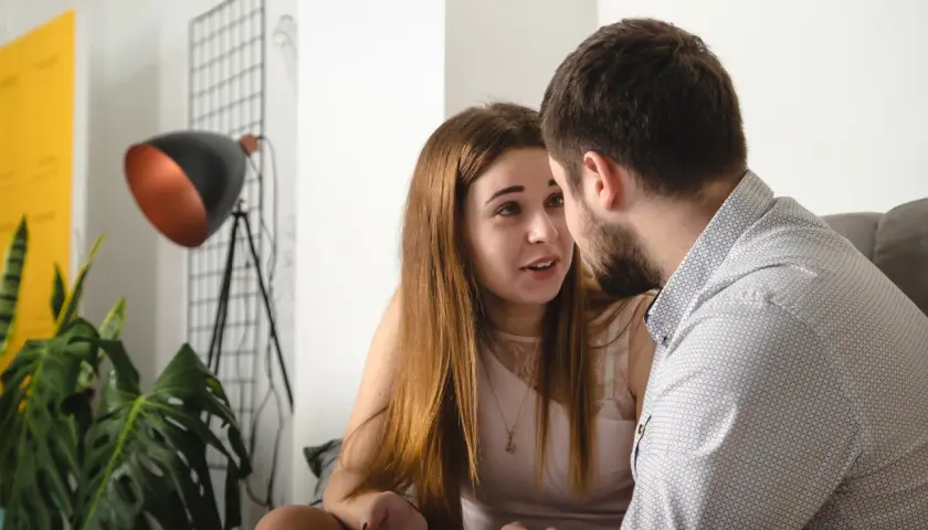 Para rozmawia, nawiązując głęboki kontakt wzrokowy. Mężczyzna w koszuli patrzy na kobietę, która gestykuluje.