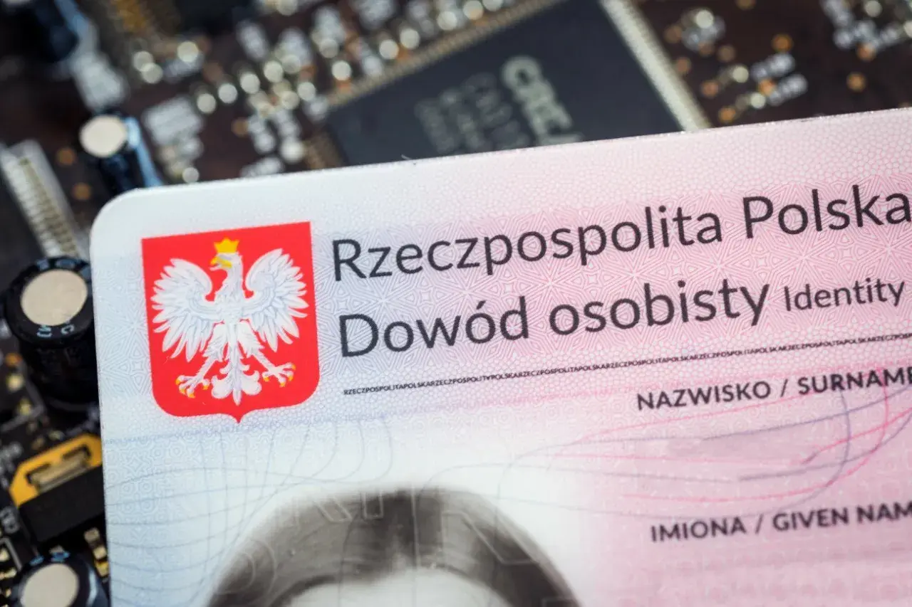 Polski dowód osobisty, z orłem w koronie, leży na płytce drukowanej. To ważny dokument, nawet tymczasowy dowód dla dziecka.