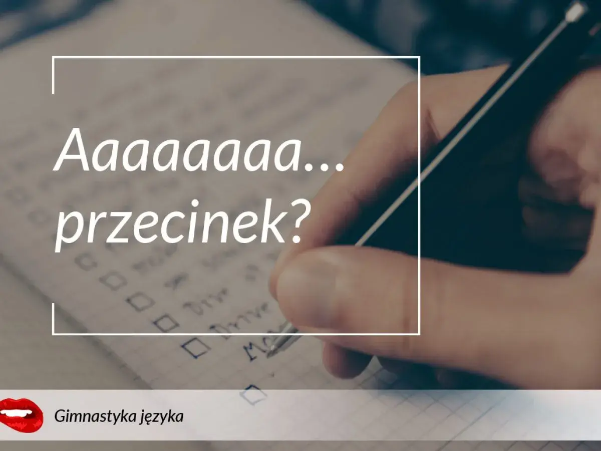 Długa litera "a" i pytanie "przecinek?" na tle notatnika, gdzie ręka pisze długopisem.