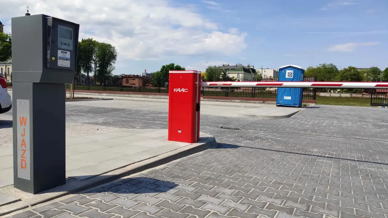 Brama wjazdowa na parking z automatem do pobierania biletów. Zastanawiasz się autopay co to? To system, który ułatwia płatności za parking.